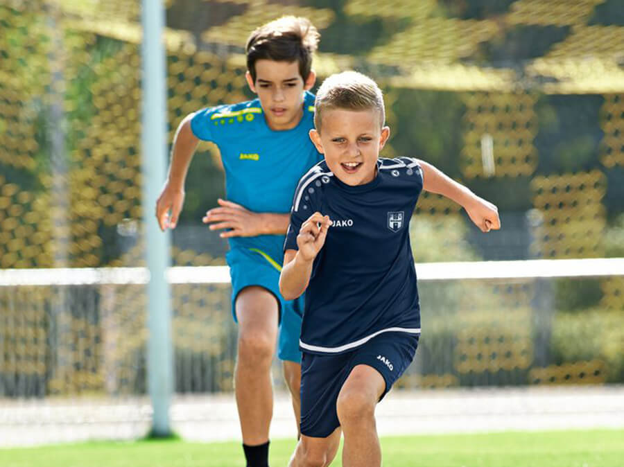 Kinderen voetballen in JAKO-truien