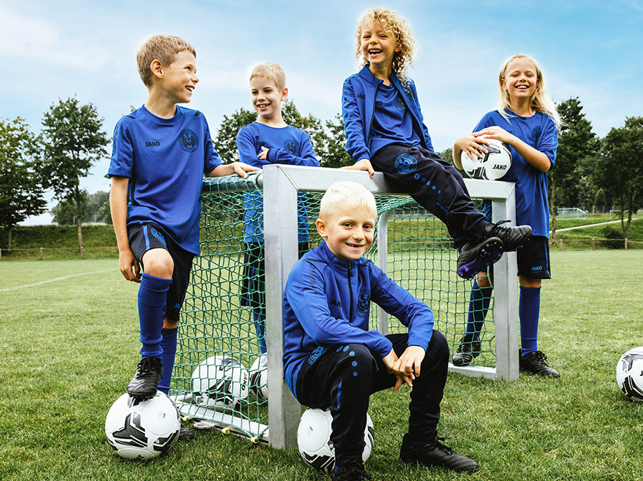 A group of children with the youth coach in JAKO tracksuits