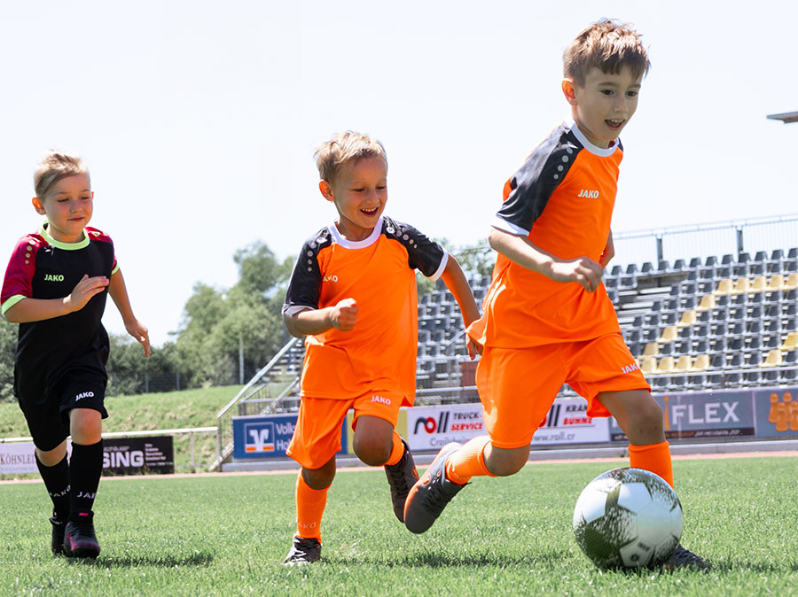Kinder beim Fußballspiel in JAKO-Trikots
