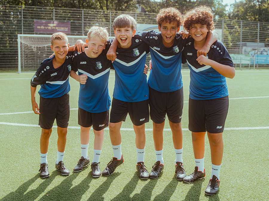 Eine Gruppe von Kindern mit dem Jugentrainer in JAKO Trainingsanzügen