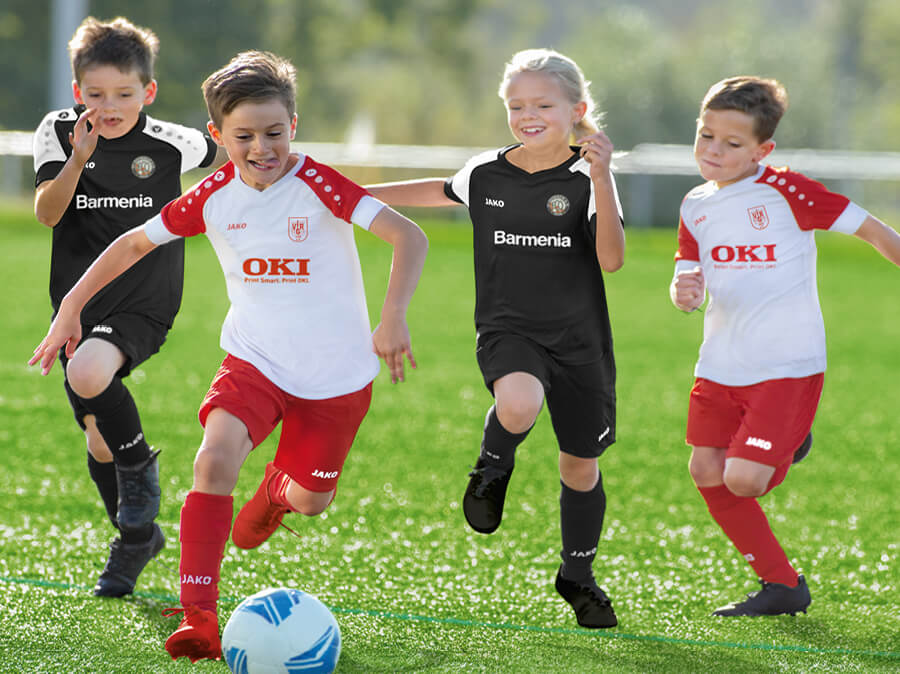 Kinder beim Fußballspiel in JAKO-Trikots