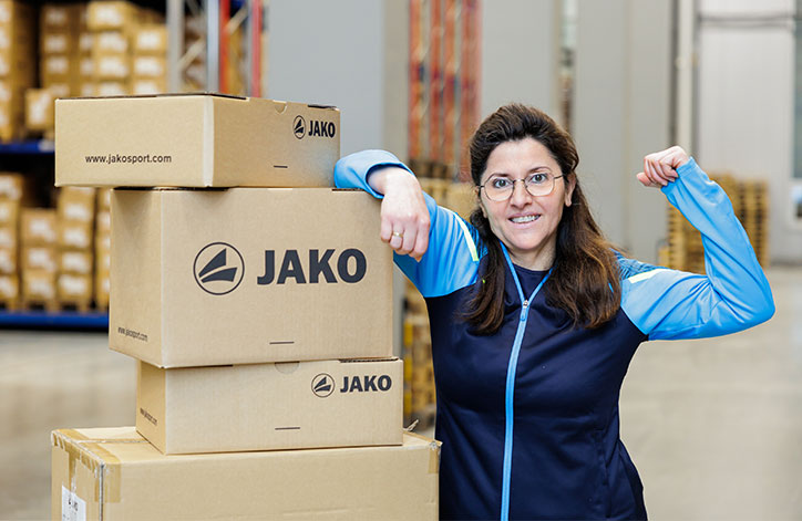 Mitarbeiterin aus der Logistik bei JAKO mit einem Stapel Pakete