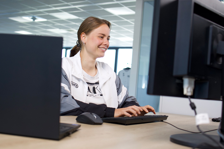 Zwei Kollegen von JAKO sitzen vor einem Laptop in einem Besprechungsraum